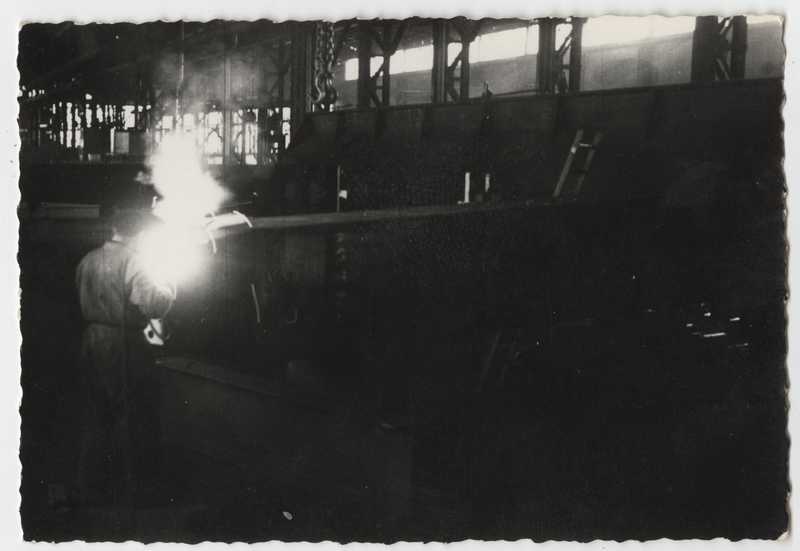 Interno del deposito di elementi prefabbricati per la costruzione di opere di presa. Operaio alla saldatura